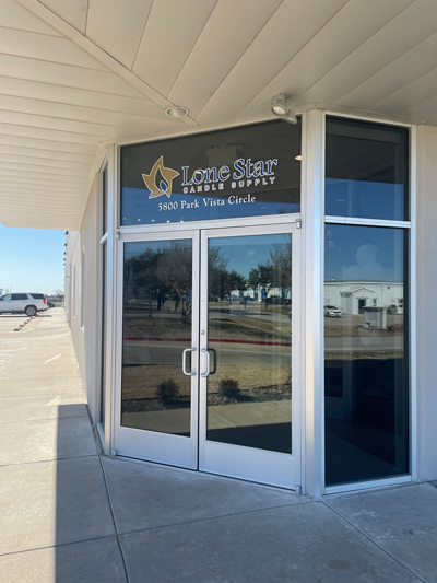 Glass double-door corner entrance with Lone Star Candle Supply sign and 5800 Park Vista Circle address