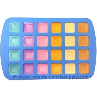 Blue silicone mold of square wax tarts in teal, purple, pink, orange, cream and tan