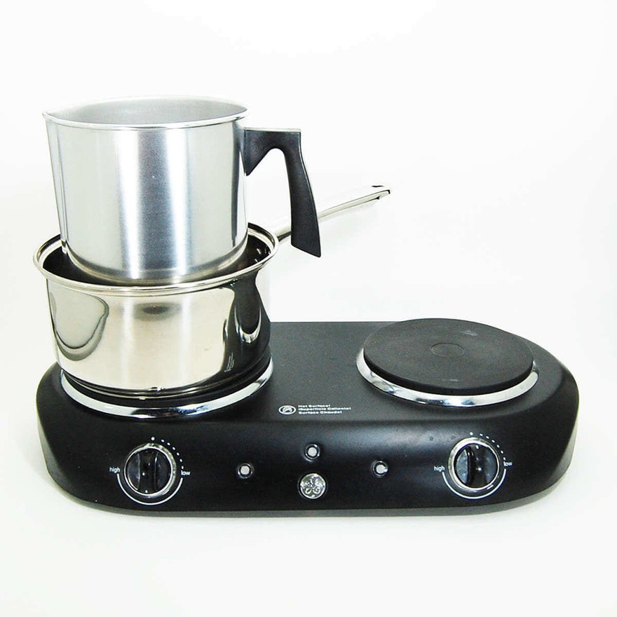 Aluminum pouring pot nested in a saucepan on a black GE two-burner hot plate