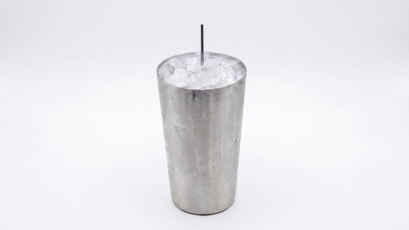 Metal cup mold packed with crushed ice around a centered metal wick rod on white