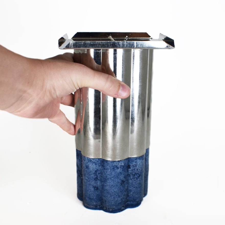 The set blue candle sliding out of the upside-down pillar mold