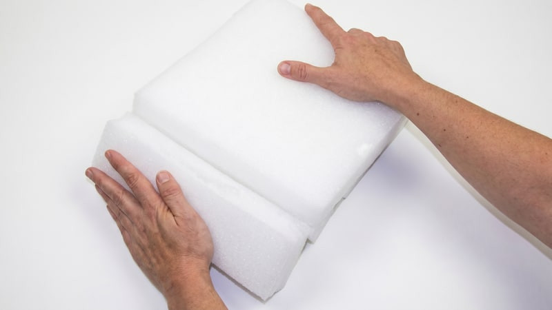 Two hands snapping a white wax slab into two pieces